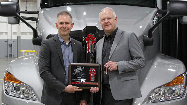 Kenworth General Manager Kevin Baney presents Heartland Express CEO Mike Gerdin with plaque and keys to #750,000